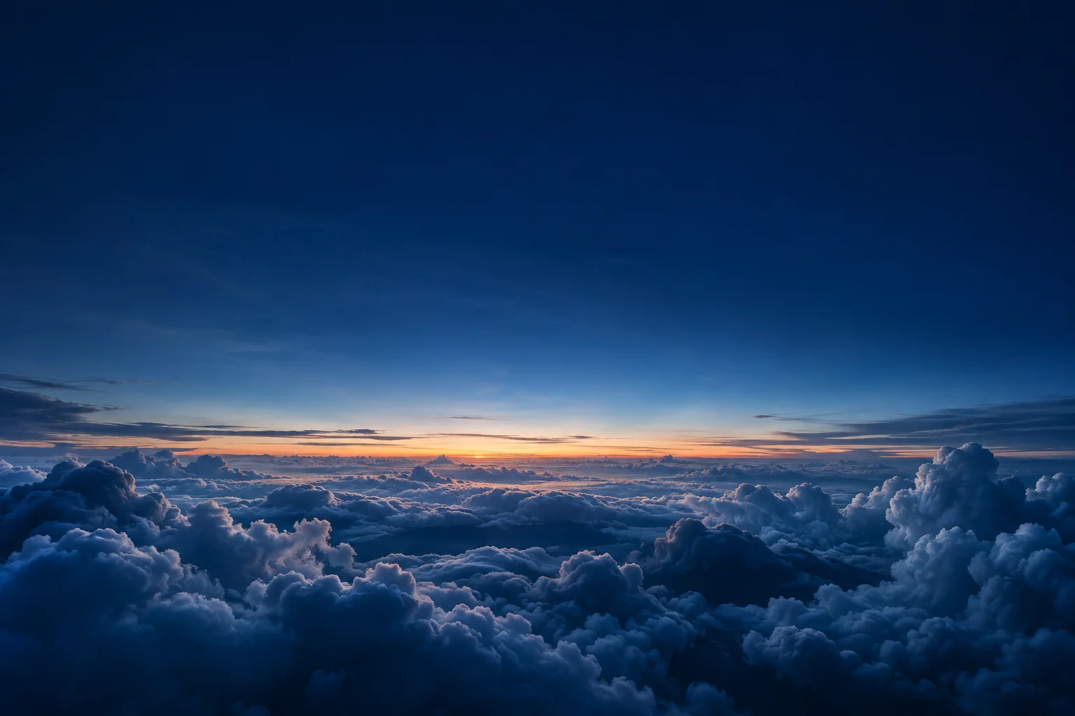 Warm sunlight breaking across a blue horizon above the clouds